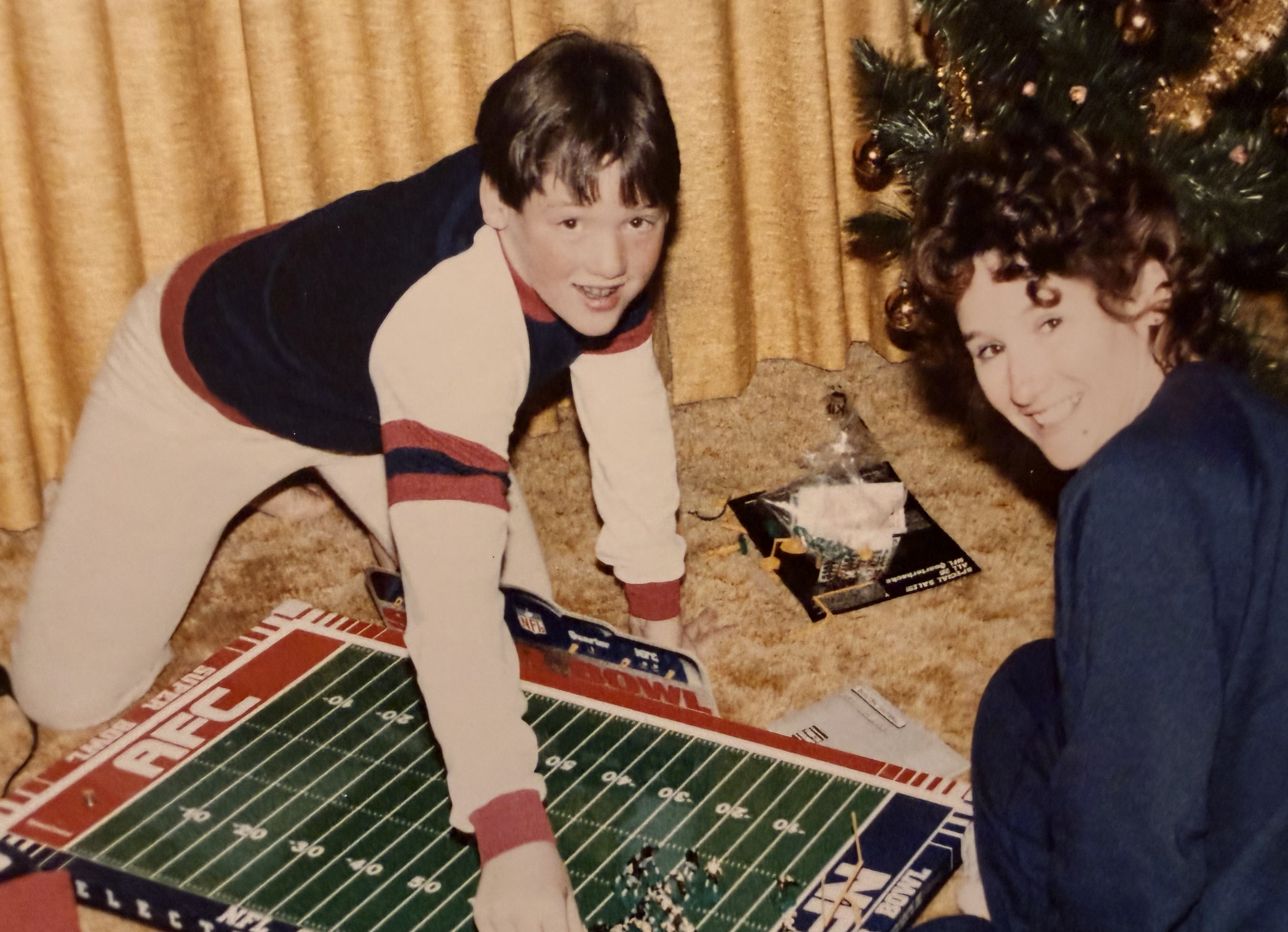 Me, at probably age 10 or 11, playing Electric Football on the living room floor. My mom is next to me, as is a Christmas tree