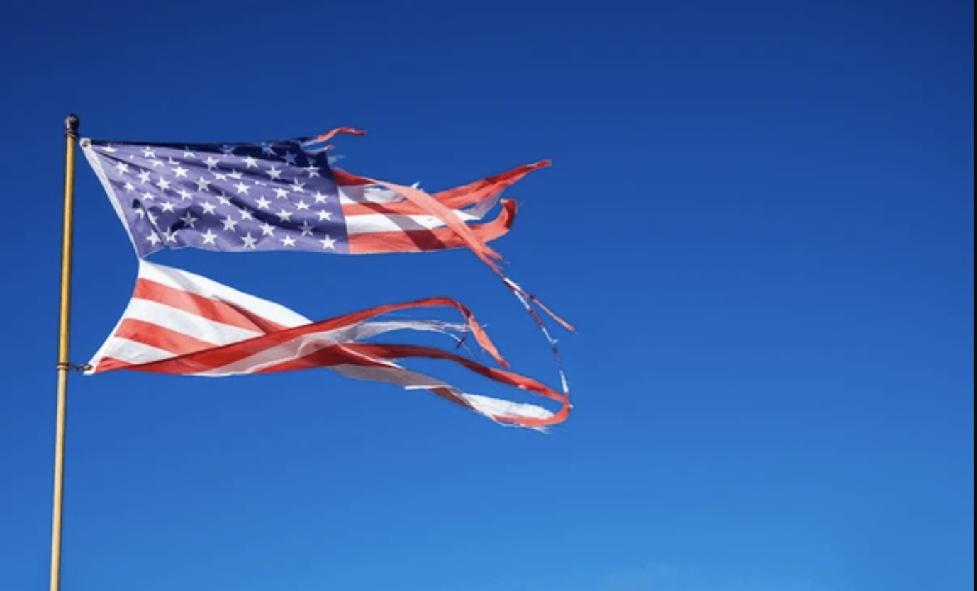 A severely tattered American flag flying from a flag pole