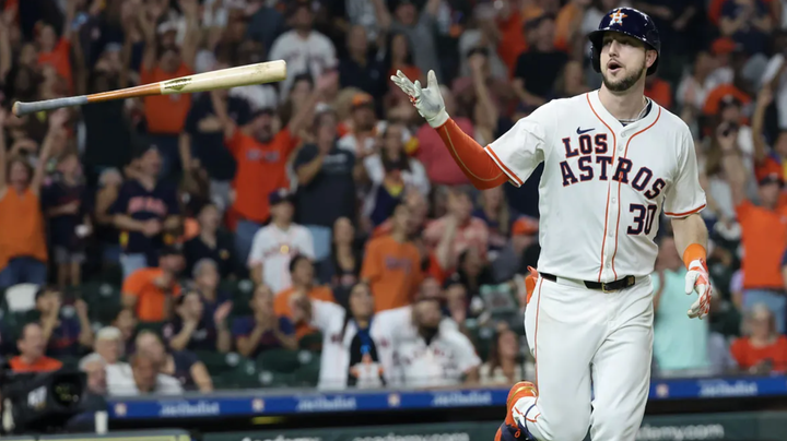 Kyle Tucker flipping a bat after a home run while wearing a "Los Astros" jersey
