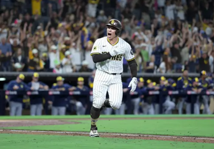 Freddy Fermin pounds his chest and the crowd in the background cheers as he hits a walkoff single which clinched a postseason spot