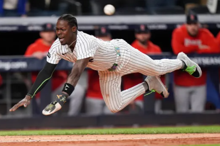 Jazz Chisholm sliding head first into home, his helmet having flown off his head
