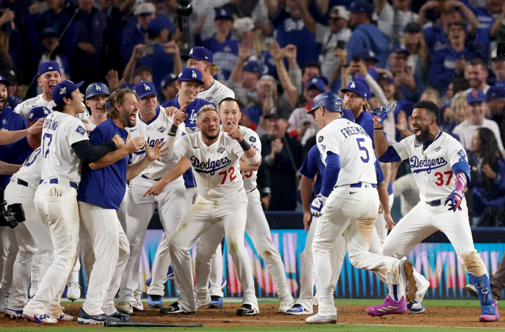 Freddie Freeman greeted by his teammates at home plate after hitting a walkoff home run to win Game 3