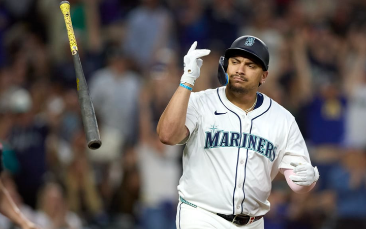 Josh Naylor in a Mariners uniform flipping a bat after hitting a home run
