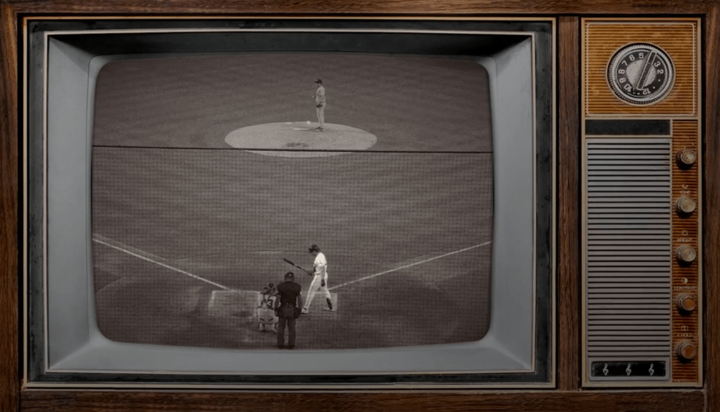 An old TV with a baseball game playing on it