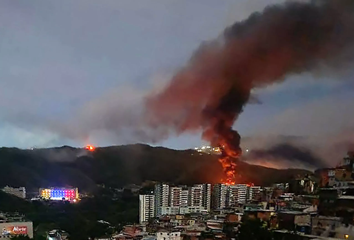 photo of Caracas with fires burning after US bombing