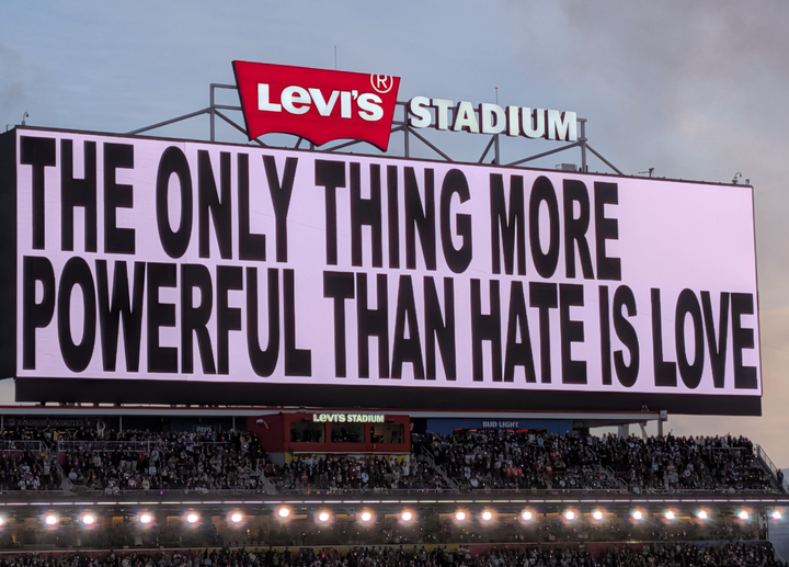 Scoreboard saying "The only thing more powerful than hate is love"